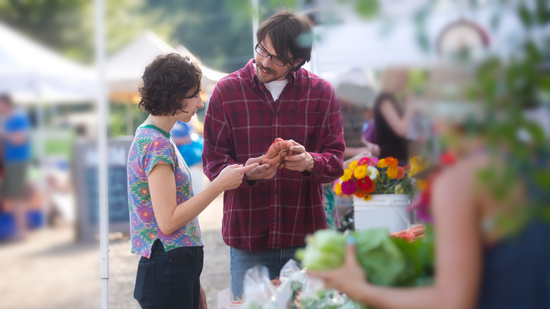 Couple shopping for fresh produce at farmers market stall